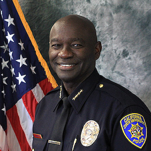 Police chief in uniform with US flag in background